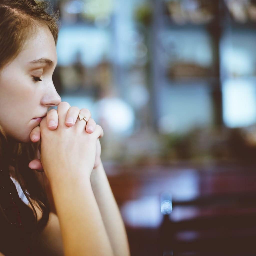 Woman with her hands crossed praying