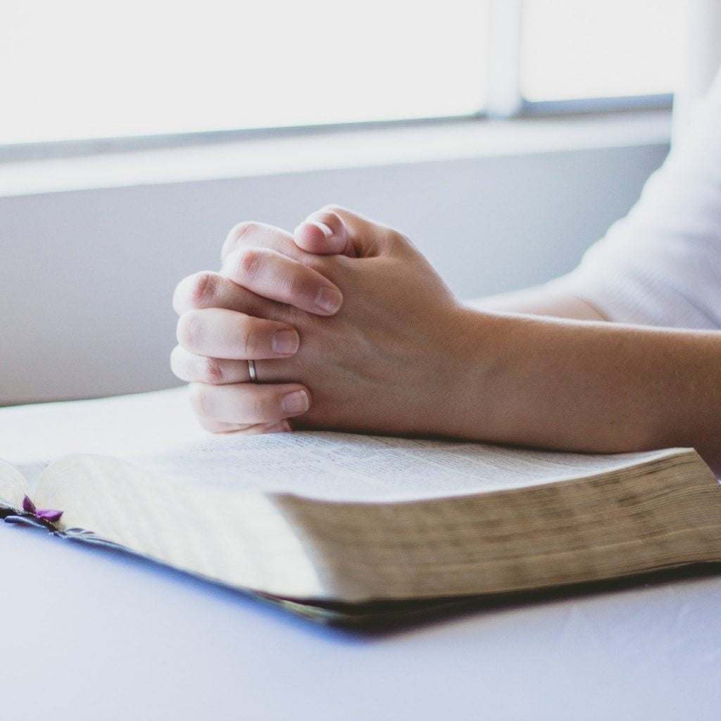 Hand on Bible Praying