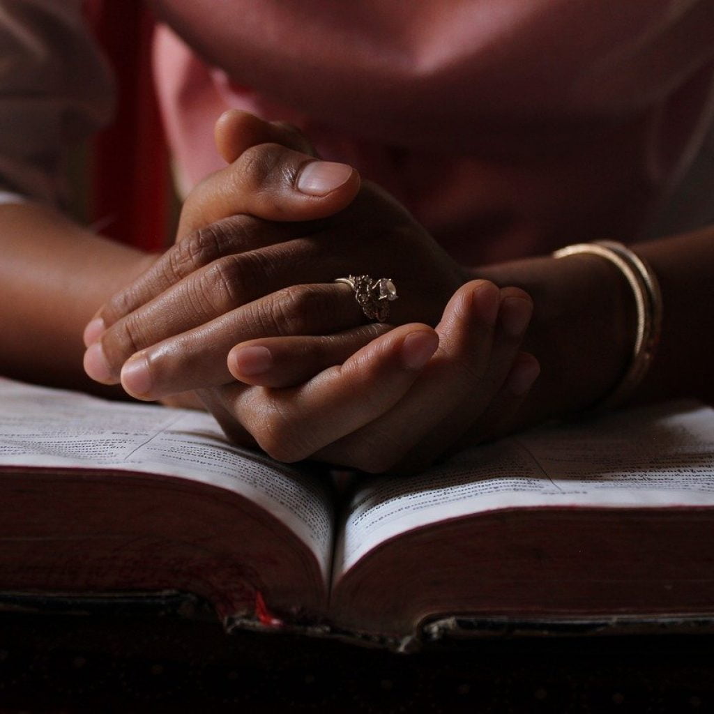 Praying hands on Bible