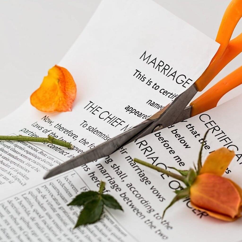 Scissor cutting a marriage certificate in half