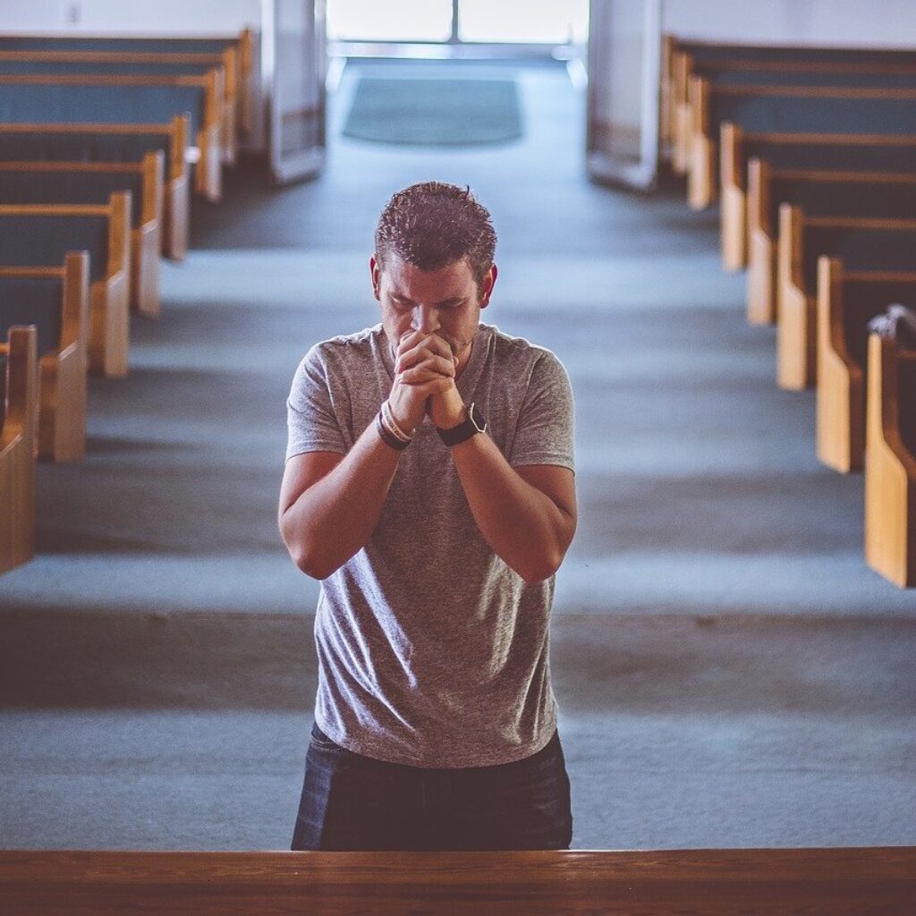 Man standing and praying in a church