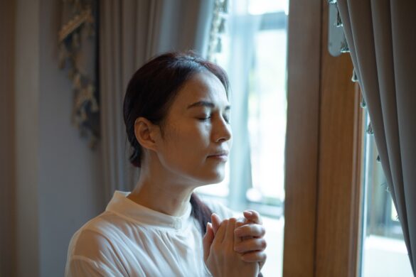 Woman praying near window