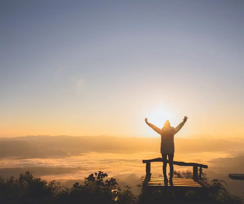 Woman at the top of a mountain enjoying God's creation