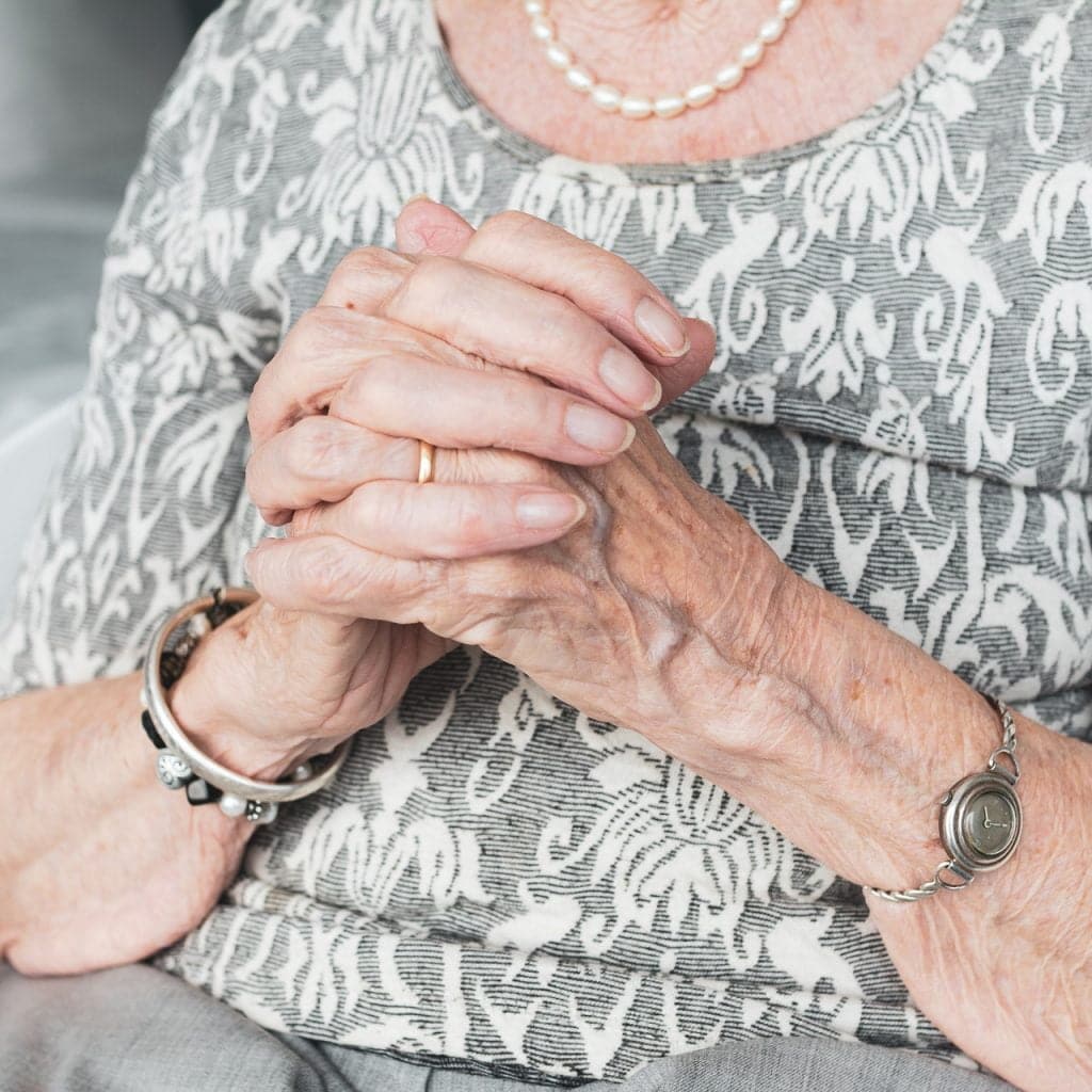 Elderly woman sitting and praying
