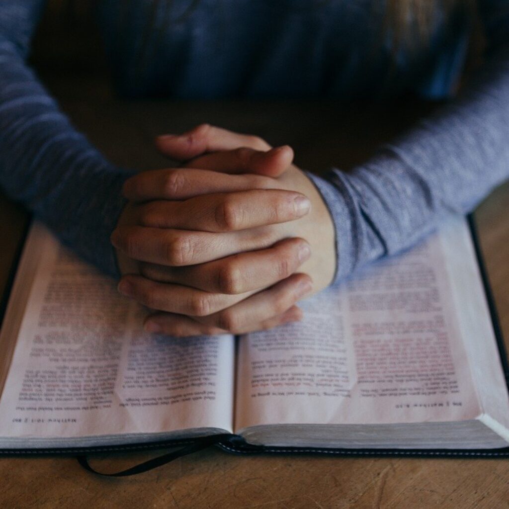 Man hand crossed on Bible praying