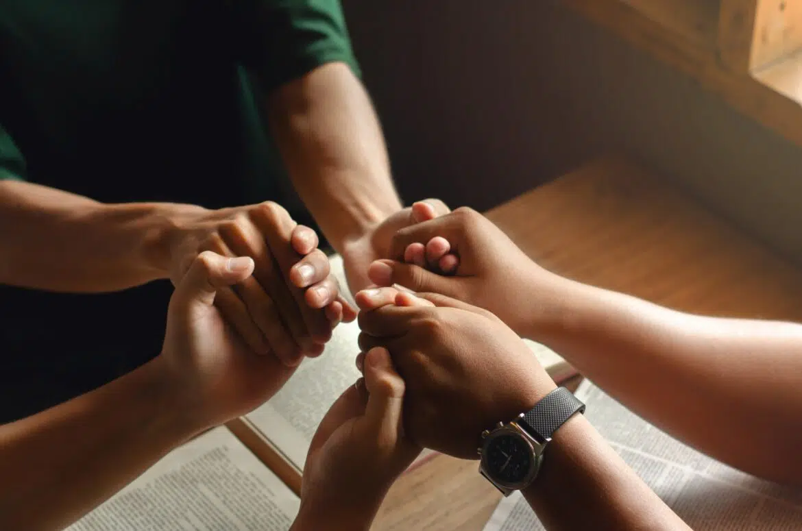 Christian group holding hands and getting closer to God
