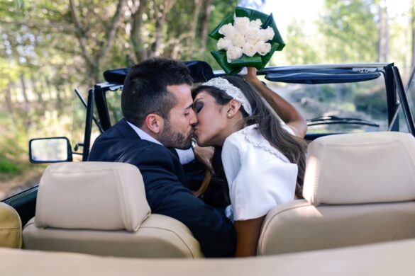 Christian newlyweds kissing in car