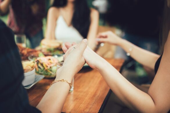 Family Praying Before Eating Meal Together