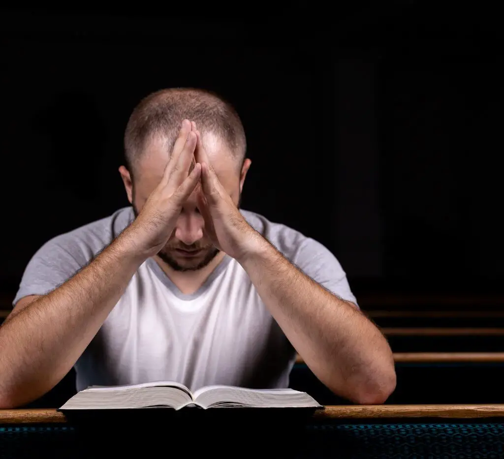 Guy praying with Bible