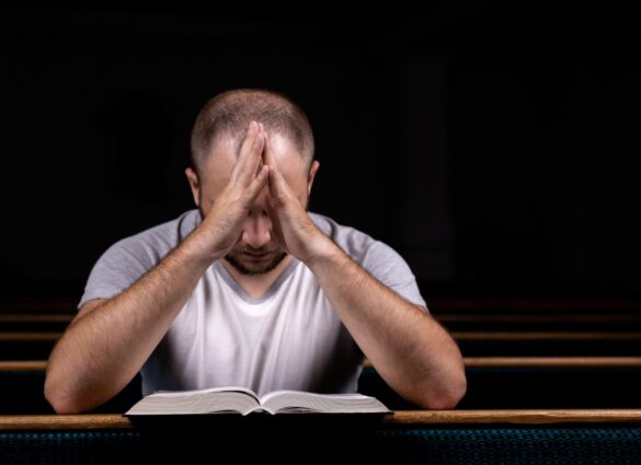 Guy praying with Bible