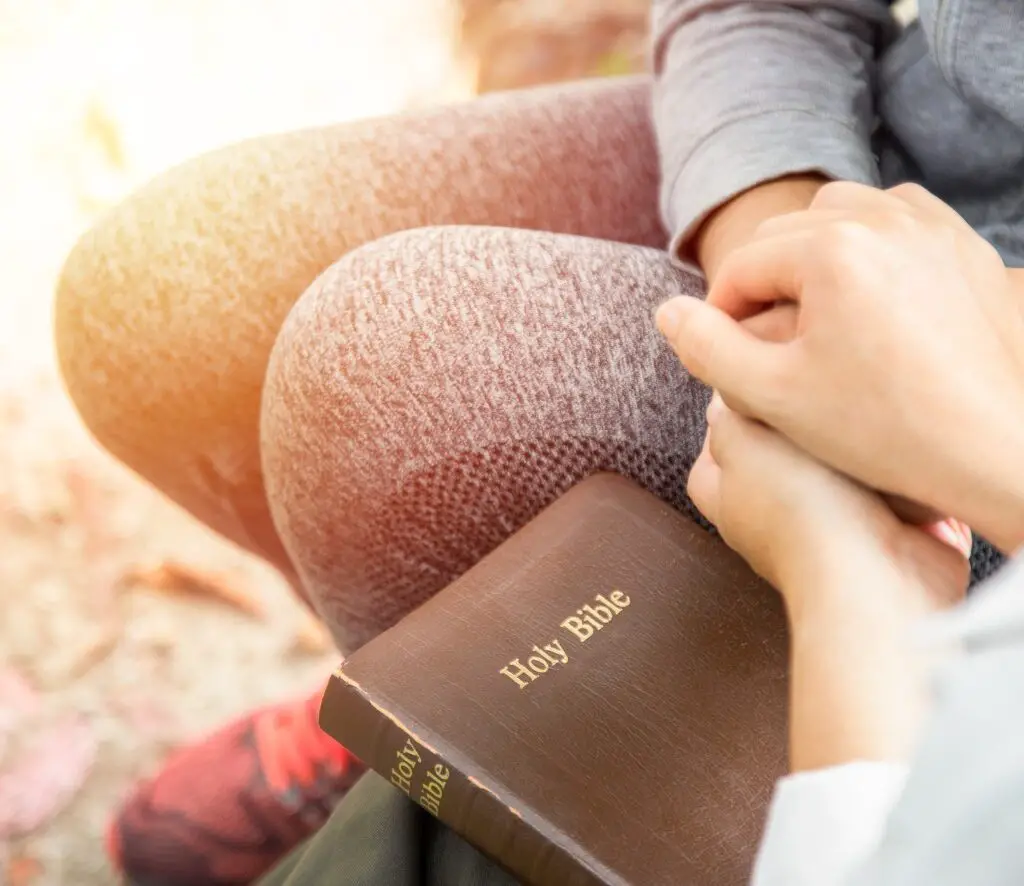 Two people holding hands and praying together