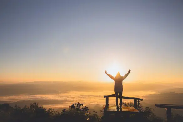 Woman at the top of a mountain enjoying God's creation