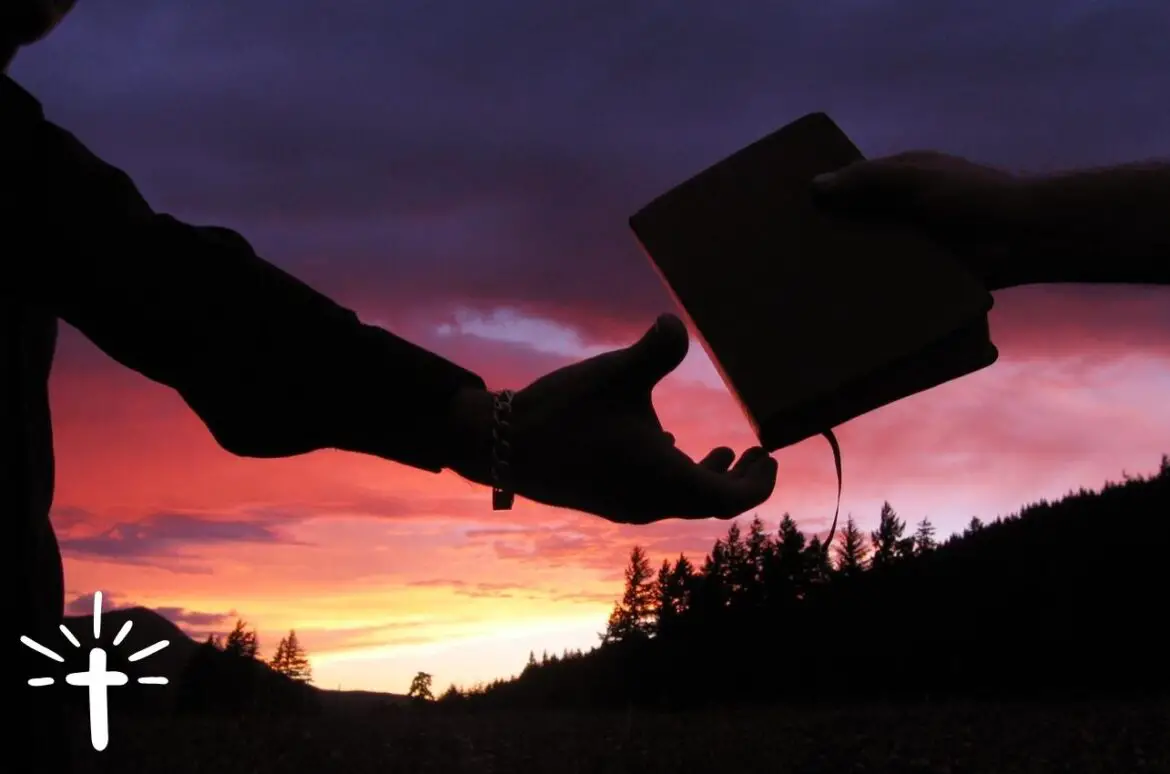 A Person Passing The Bible To Another Person’s Hand A Person Passing The Bible To Another Person's Hand