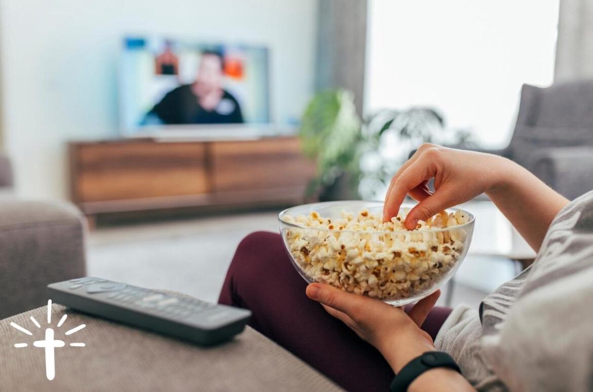 Christian Woman Watching TV and Eating Popcorn